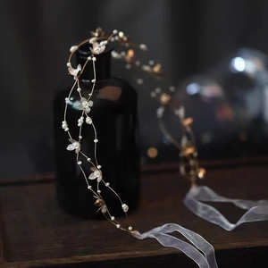 Elegant bridal hair vine with white flowers, gold leaves and pearls on dark background