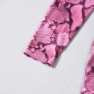 Dettaglio del polsino con stampa serpente rosa che mostra tessuto elastico e cuciture