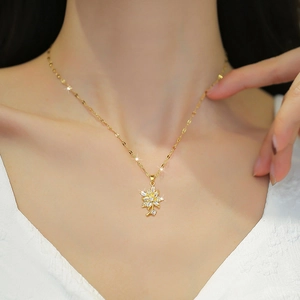Elegant gold titanium necklace with a sparkling flower pendant on a female model