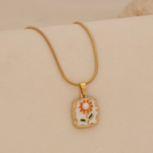Gros plan du collier vintage doré avec pendentif tournesol en perle et chaîne serpent