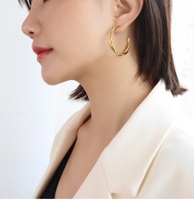 Side view of model wearing twisted double layer gold earrings made of durable titanium steel