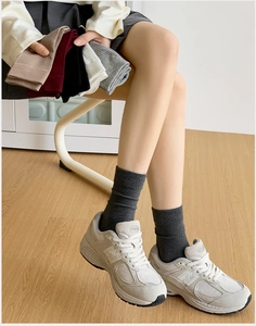 Detailed macro view of cotton ribbed crew socks in multiple colors shown on a model