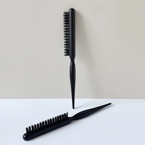 Detail of professional black hair styling brushes with fine bristles and sectioning tail