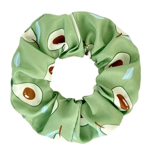Detailed view of a green avocado print scrunchie with a soft silk-like texture fabric