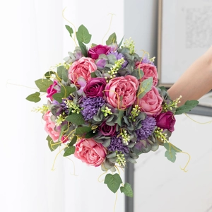Artificial pink rose and purple flower bouquet with lush green leaves for home decor