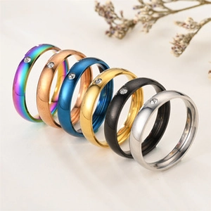 Polished titanium steel rings with inlaid diamonds in six colors on beige background
