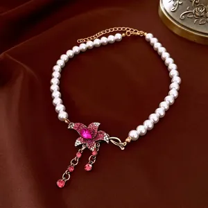 French vintage pearl necklace featuring a pink floral rhinestone pendant and golden tassels