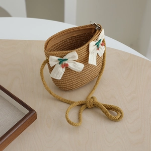Détail du sac bandoulière en paille pour filles avec nœuds blancs et cerises rouges
