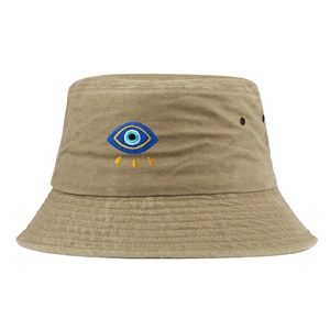 Gros plan détaillé montrant la broderie de l'œil maléfique sur un chapeau bob kaki