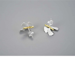 Macro view of handmade S925 silver butterfly studs with gold brushed wing details