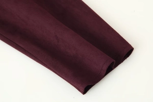 Close-up of the precision stitching and suede texture on burgundy jacket cuffs