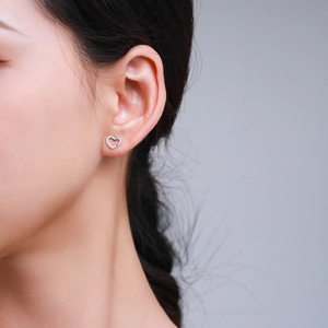 Elegant sterling silver heart stud earrings shown on model for a minimalist look