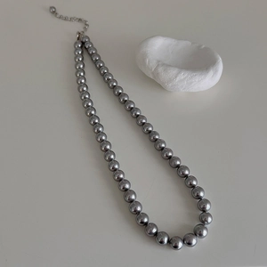 Detailed view of dark grey pearl necklace with silver adjustable lobster clasp