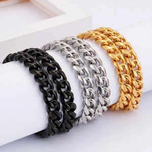 Detailed view of Cuban chain bracelets in gold, silver, and black on a white stand