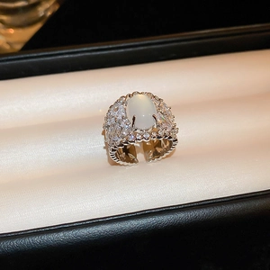 Detail of vintage luxury silver ring with oval white gemstone and pave zircon border