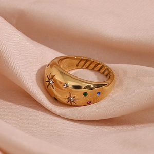 Macro detail of 18K gold plated dome ring with colorful stones on pink silk fabric