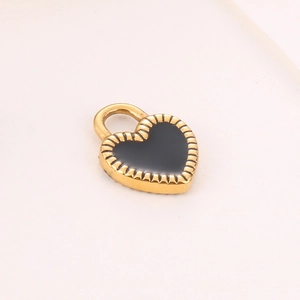 Golden heart pendant with black enamel inlay and round bail on a soft pink background