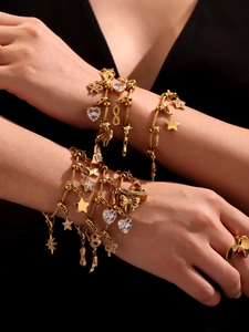 Gros plan de bracelets en acier inoxydable plaqué or 18K avec breloques cœur et infini