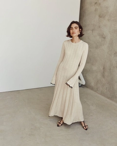 Détail des manches évasées avec bordure ondulée noire sur une robe en maille beige