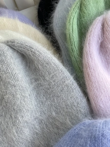 Detailaufnahme bunter Angora-Kaninchenfellmützen mit weicher Plüschtextur