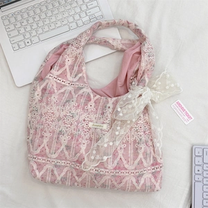 Detailed close-up of pink lace tote bag with floral embroidery and white ribbon bow