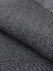Détail du tissu tissé gris foncé montrant la texture et la qualité du matériau