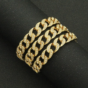 Men's gold Cuban link bracelet with sparkling rhinestones in a coiled jewelry display