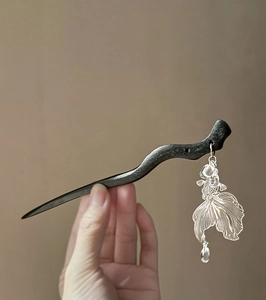 Detail of ebony wood hair stick with silver fish tassel and transparent beads