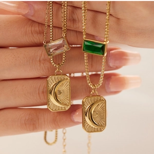 Detail of double-layer gold necklaces featuring sun and moon pendants with zircon stones