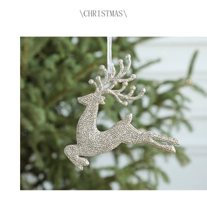 Nahaufnahme von goldenem Glitzer-Rentier-Anhänger an einem festlichen Weihnachtsbaum
