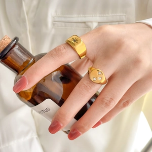 Vintage gold-plated signet rings with black stone and cubic zirconia on a female hand