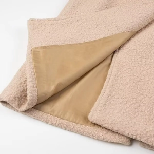 Detail of beige fleece exterior and smooth khaki lining fabric texture of the long coat