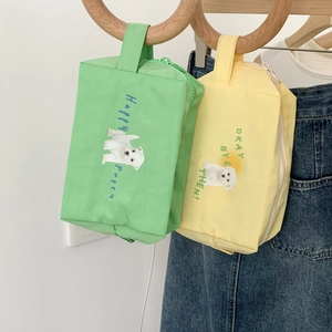Close-up of green and yellow nylon cosmetic bags with cute puppy prints and top handles
