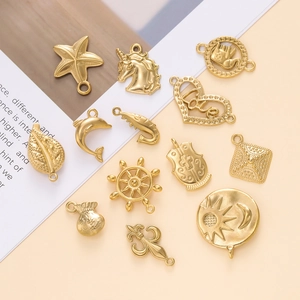 Macro view of gold-plated stainless steel charms featuring starfish and sea motifs for DIY