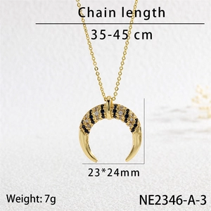 Detail view of crescent moon pendant with blue and white zircons in golden finish