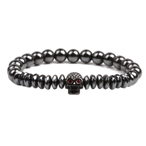 Men's natural black stone beaded bracelet with a skull charm and red gemstone eyes