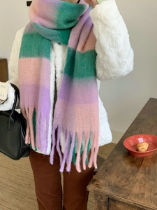 Close-up of rainbow plaid tassel scarf featuring pink green and purple gradient knit texture