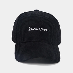 Detailed close-up of Baba embroidery on black corduroy baseball cap with striped texture