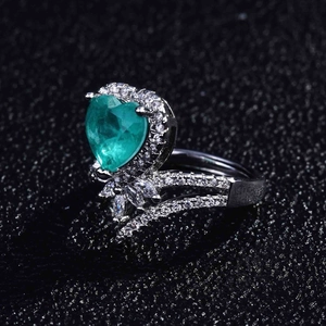 Macro shot of heart-shaped Paraiba stone and micro-pave diamonds on silver ring band