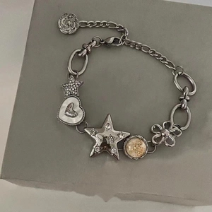 Metallic star and heart charm bracelet with floral pendants and silver chain design