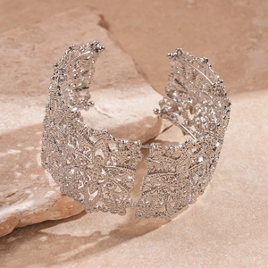 Vue détaillée d'un bracelet manchette vintage argenté avec motifs floraux ajourés et dentelle