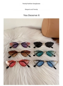 Flat lay of cat-eye sunglasses with rhinestone edges in six colors on white faux fur