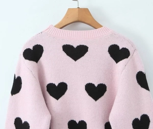 Detail of pink knitted sweater back with black heart jacquard pattern and round neck