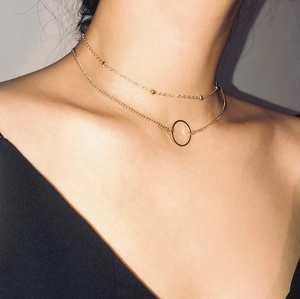Minimalist gold-layered chain necklace with circular pendant on female model