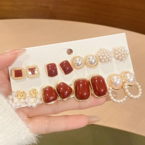 Detail of red heart pearl earring set on display card with elegant gold finish