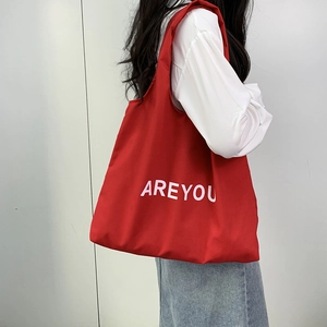 Detail of red canvas tote bag with AREYOU print and spacious interior design