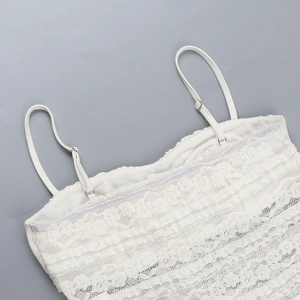 Detailed close-up of intricate white floral lace patterns and adjustable thin straps