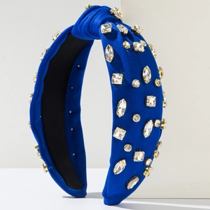 Serre-tête noué bleu roi avec strass étincelants sur un support blanc minimaliste