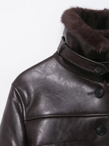 Detail of faux fur collar and dark leather texture on a vintage brown jacket