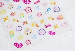 Close-up of hand-drawn 5D nail art stickers with colorful hearts and stars motifs